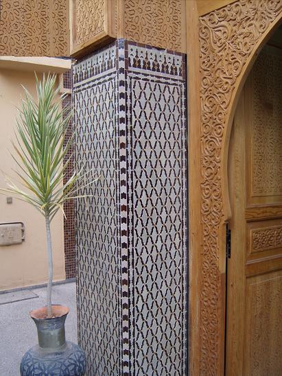 Colorful Moorish mosaic tile from Justmorocco featuring intricate Moroccan tile patterns in vibrant blue, yellow, and white.
