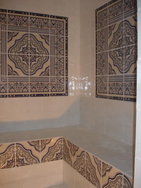 Moroccan Riad tile from Justmorocco displayed in a bathroom setting, featuring intricate geometric patterns in vibrant colors.