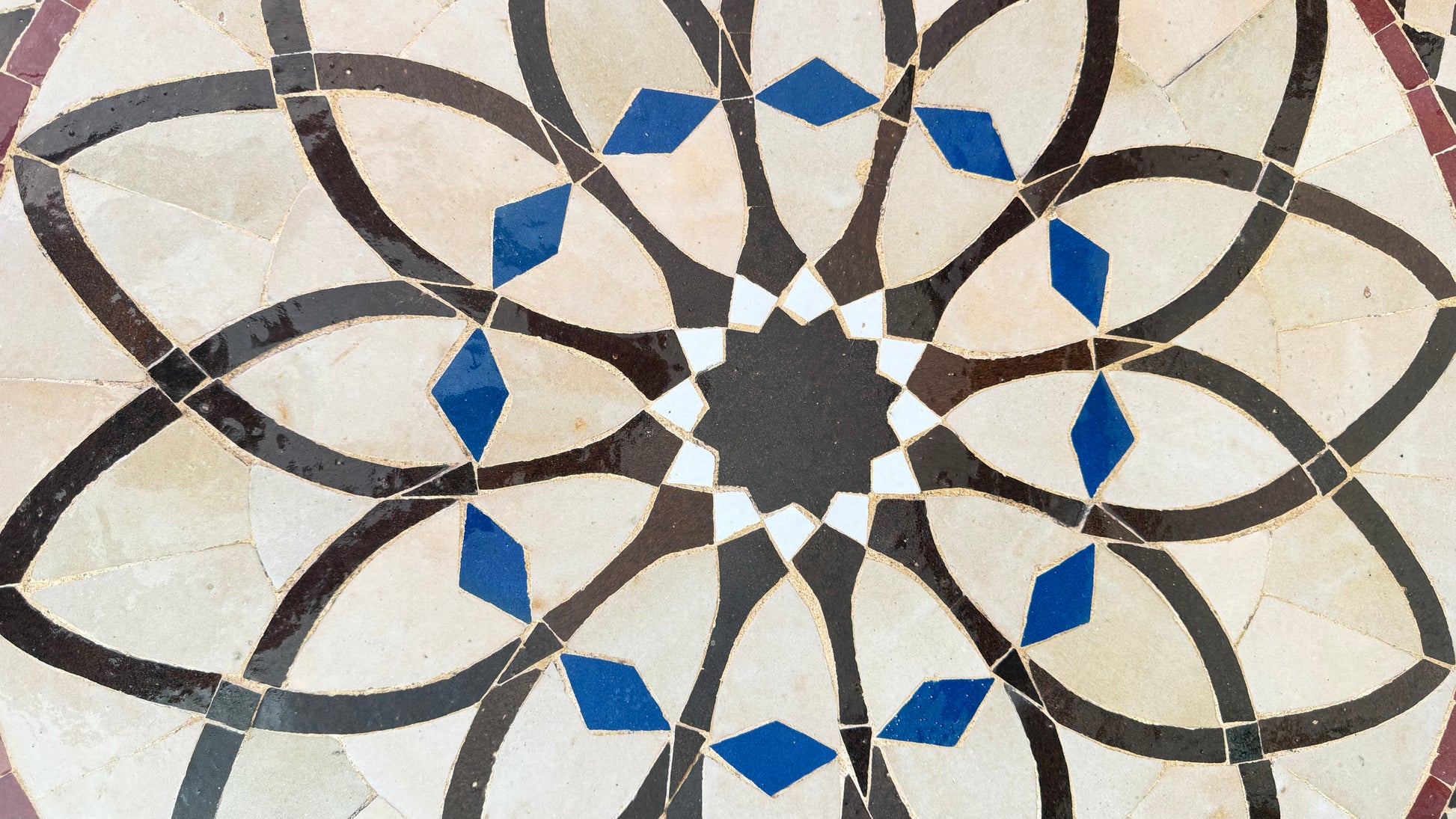 Moroccan Alhambra Palace tile by Justmorocco featuring intricate blue and white geometric patterns on ceramic surface.