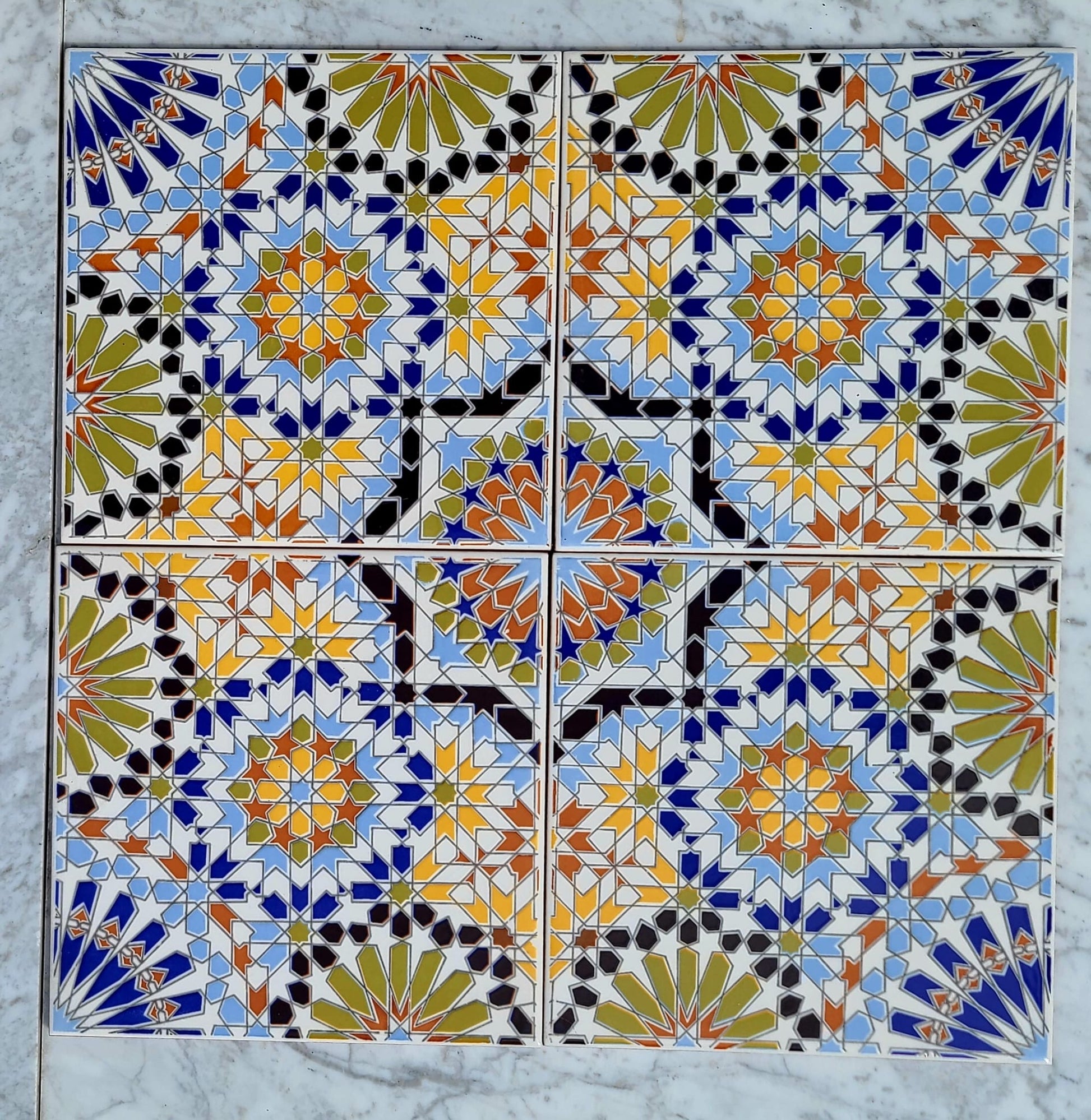 Colorful Moroccan tile by Justmorocco with intricate geometric patterns, showcasing vibrant blues and earthy tones.