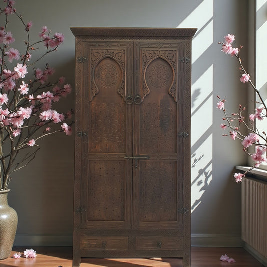 Wooden carved armoire with floral decorations in a room with sunlight streaming in