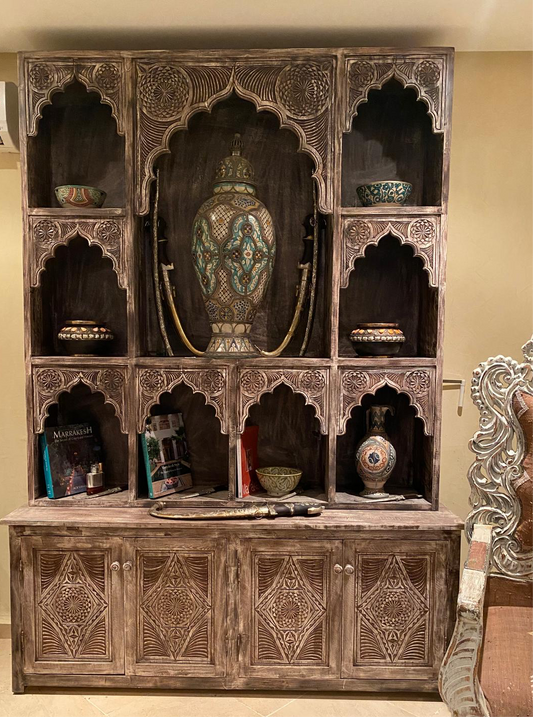 A Moroccan shelf cabinet with arched door panels and multiple shelves, featuring handmade arches and patterns, in a rustic style.