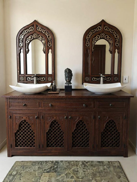 Wooden vanity with two ornate mirrors and two white sinks.