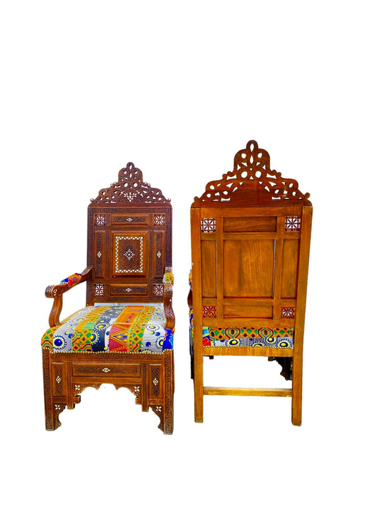 A vintage Syrian wooden chair with hand-carved lattice artwork and colorful upholstered seat and backrest.