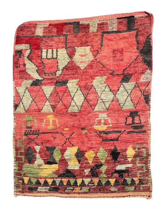 A multicolored, geometric-patterned wool rug, predominantly in blue and red, with abstract tufted designs.