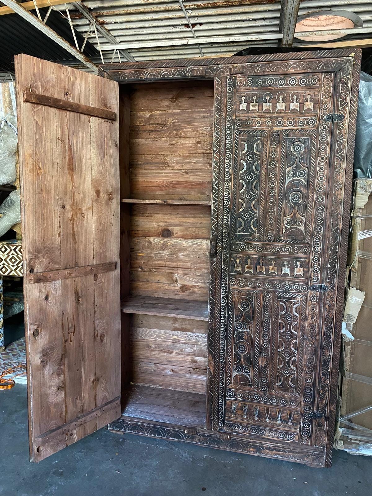 Handmade Touareg African wooden armoire with Moroccan tribal design, featuring intricate carvings, ideal for a unique bedroom storage piece.