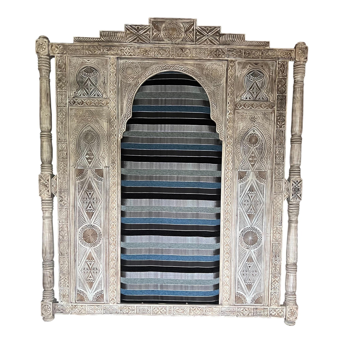 Moroccan carved headboard with Sabra upholstery, showcasing intricate woodwork and rich cultural design for a stylish bed.